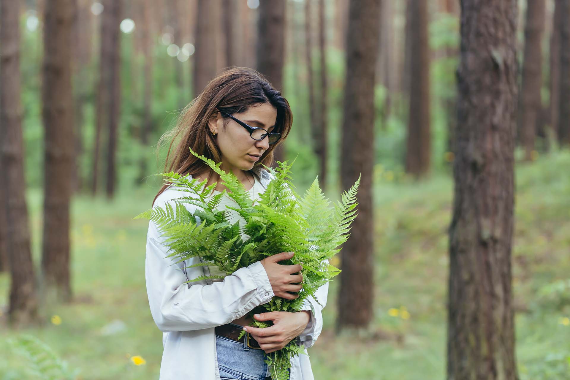 An individual meditating amidst a lush forest, symbolizing the therapeutic benefits of connecting with nature through eco-therapy