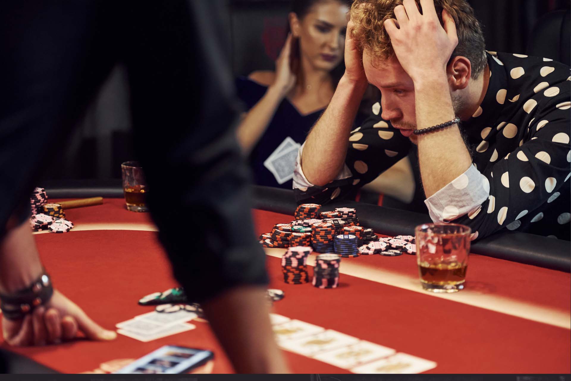 A person sitting at a table with gambling chips and a reflective expression, symbolizing the struggles of Gambling Disorder.