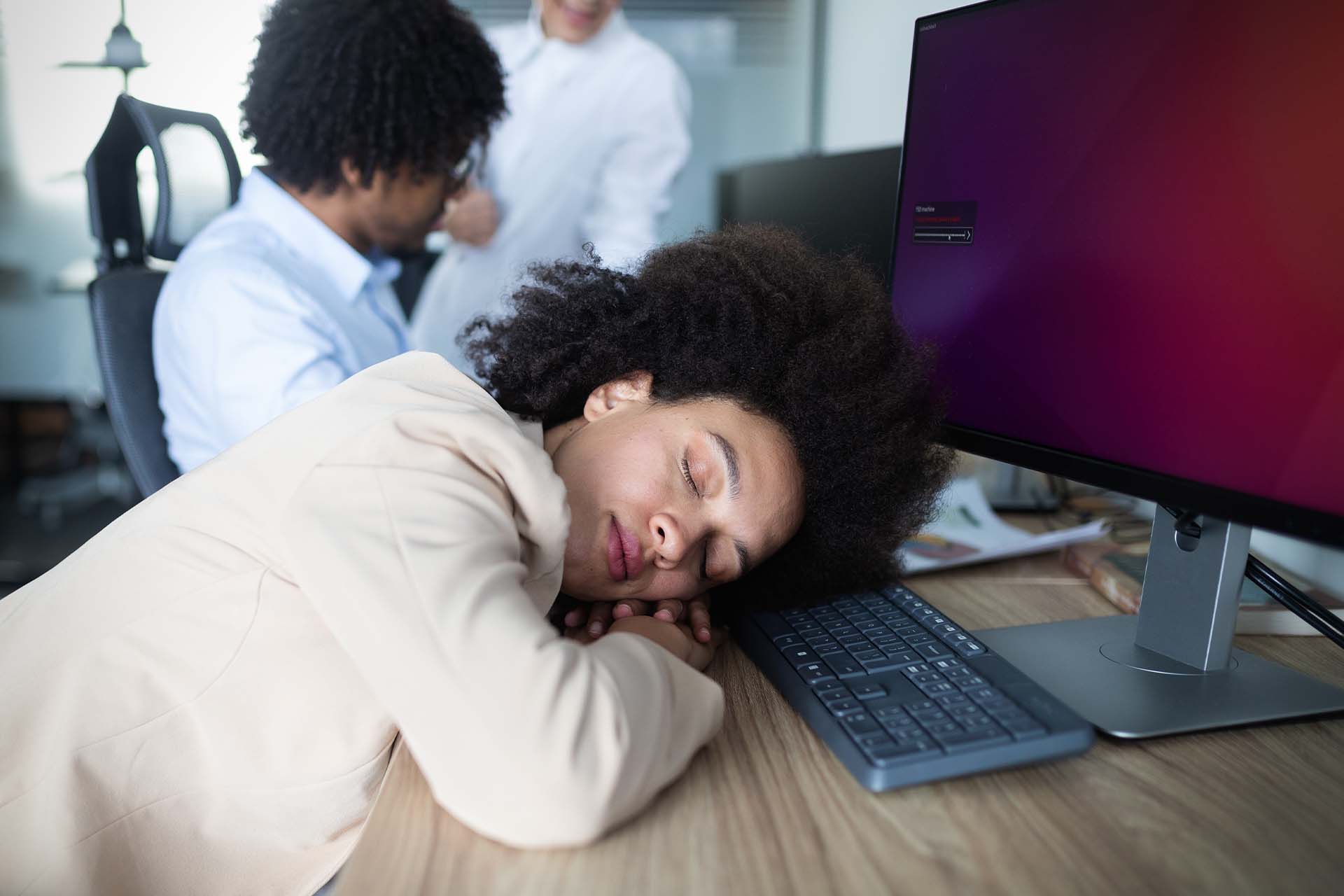 A person resting their head on a desk, symbolizing the fatigue and challenges of Hypersomnolence Disorder.