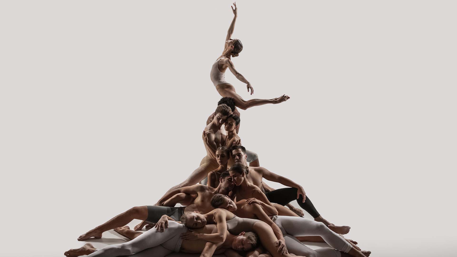 A group of performers forming an intricate human pyramid, symbolizing collaboration, balance, and staying calm under pressure.