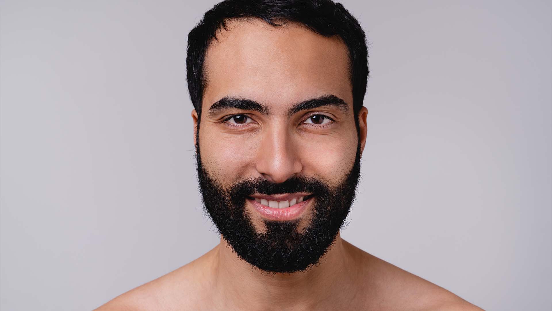 A confident man with a warm smile symbolizing self-awareness, positive growth, and holistic mental well-being, key themes in Adlerian Therapy.