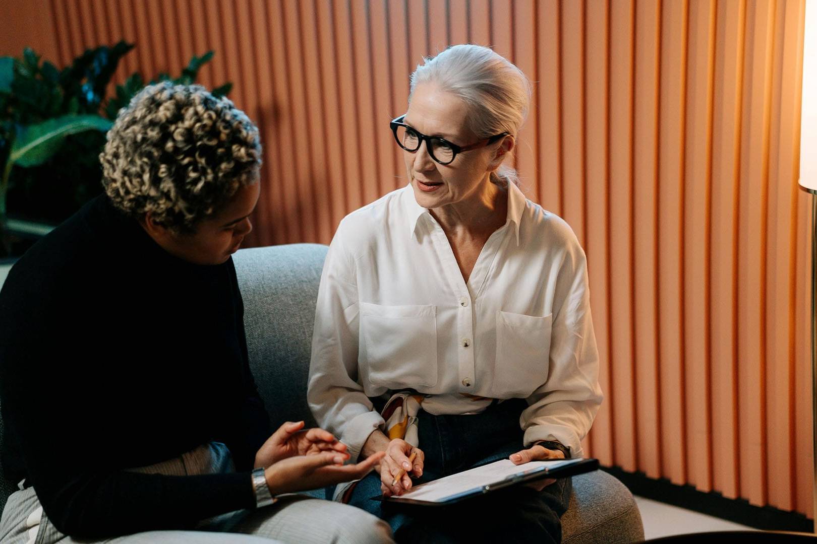 An executive woman discusses her experiences with a therapist during a one-on-one EMDR therapy session.