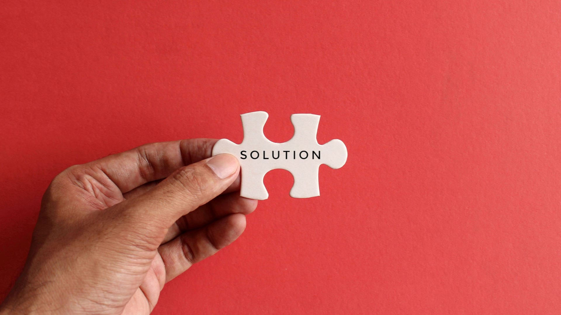 Hand holding a puzzle piece labeled 