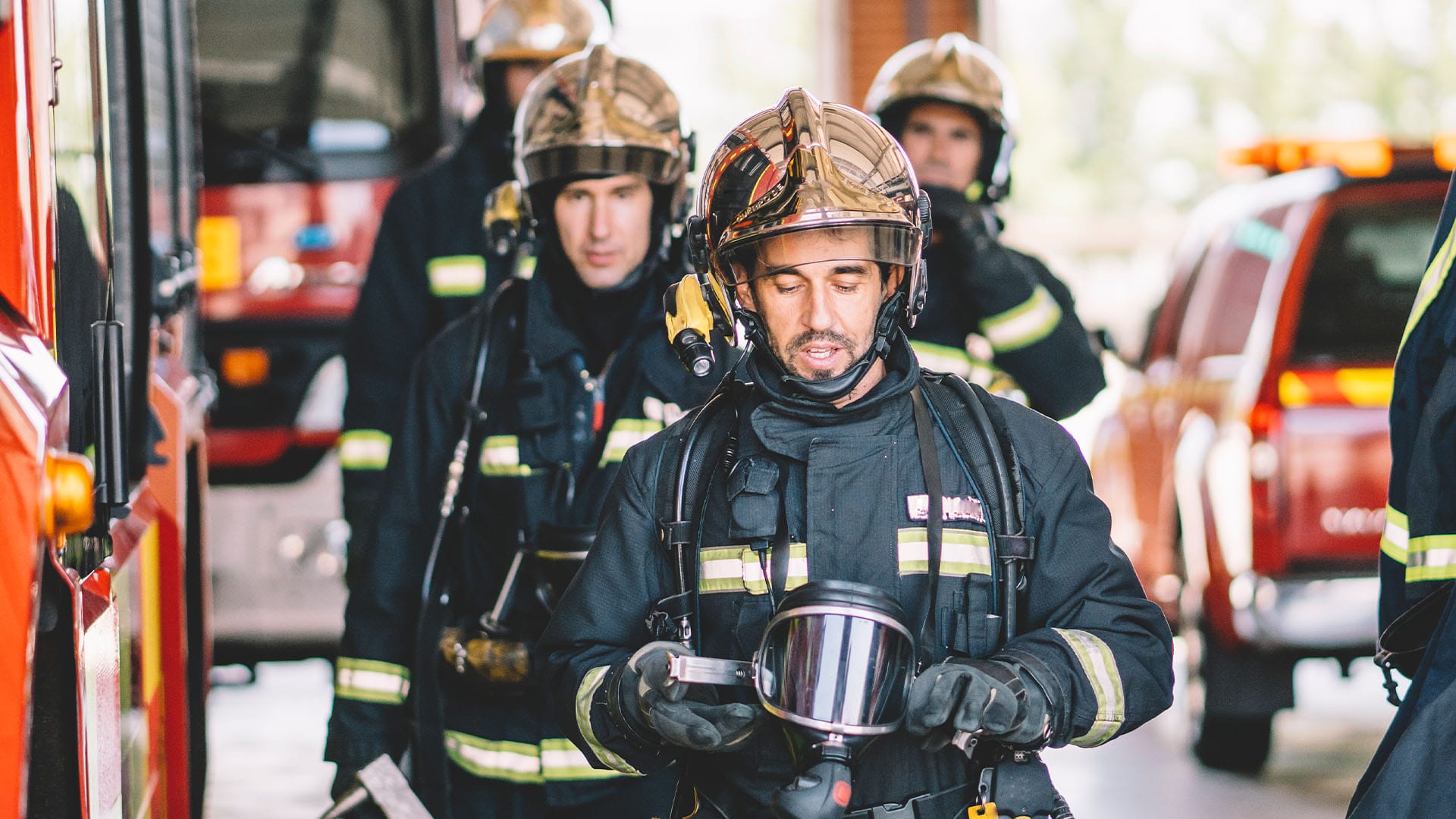 CAL FIRE firefighter holds protective mask after a call, symbolizing exhaustion and the hidden toll of front-line service.