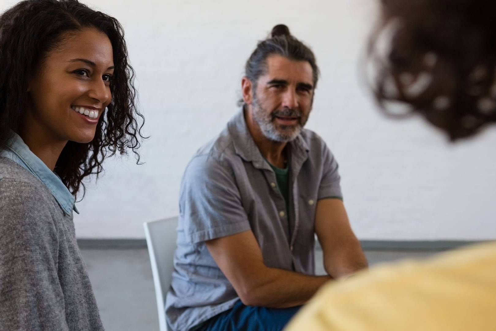 Support group participants smiling and engaging during a therapy session in Encinitas and Olivenhain, CA.