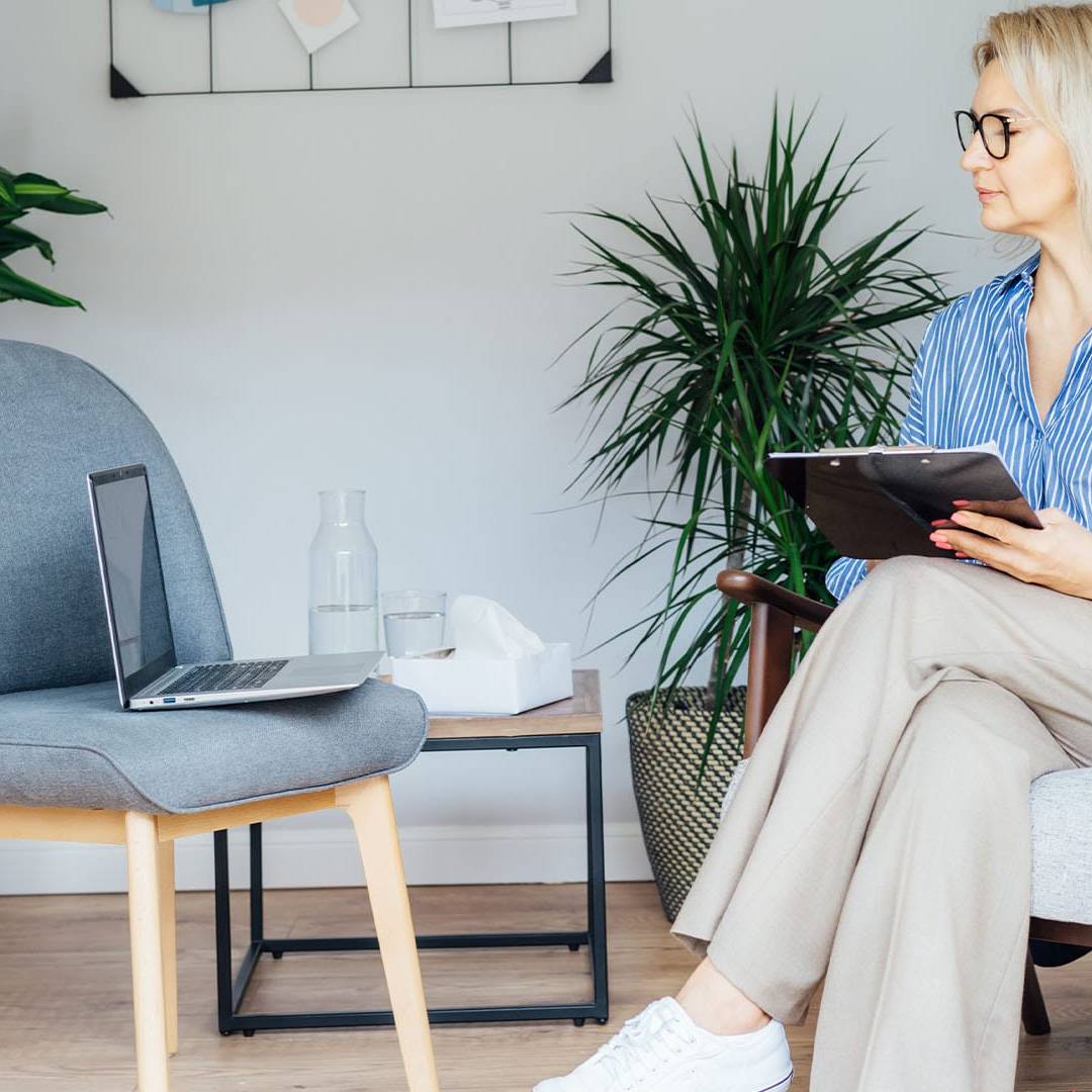 Therapist taking notes while preparing for an online session
