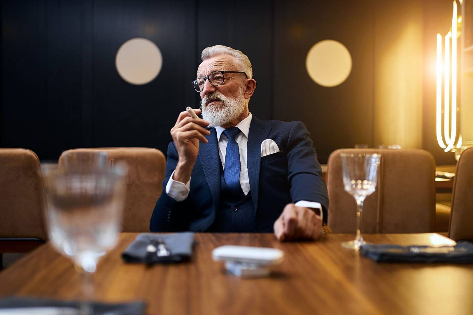 Distinguished man in a suit sitting at a table in an upscale setting