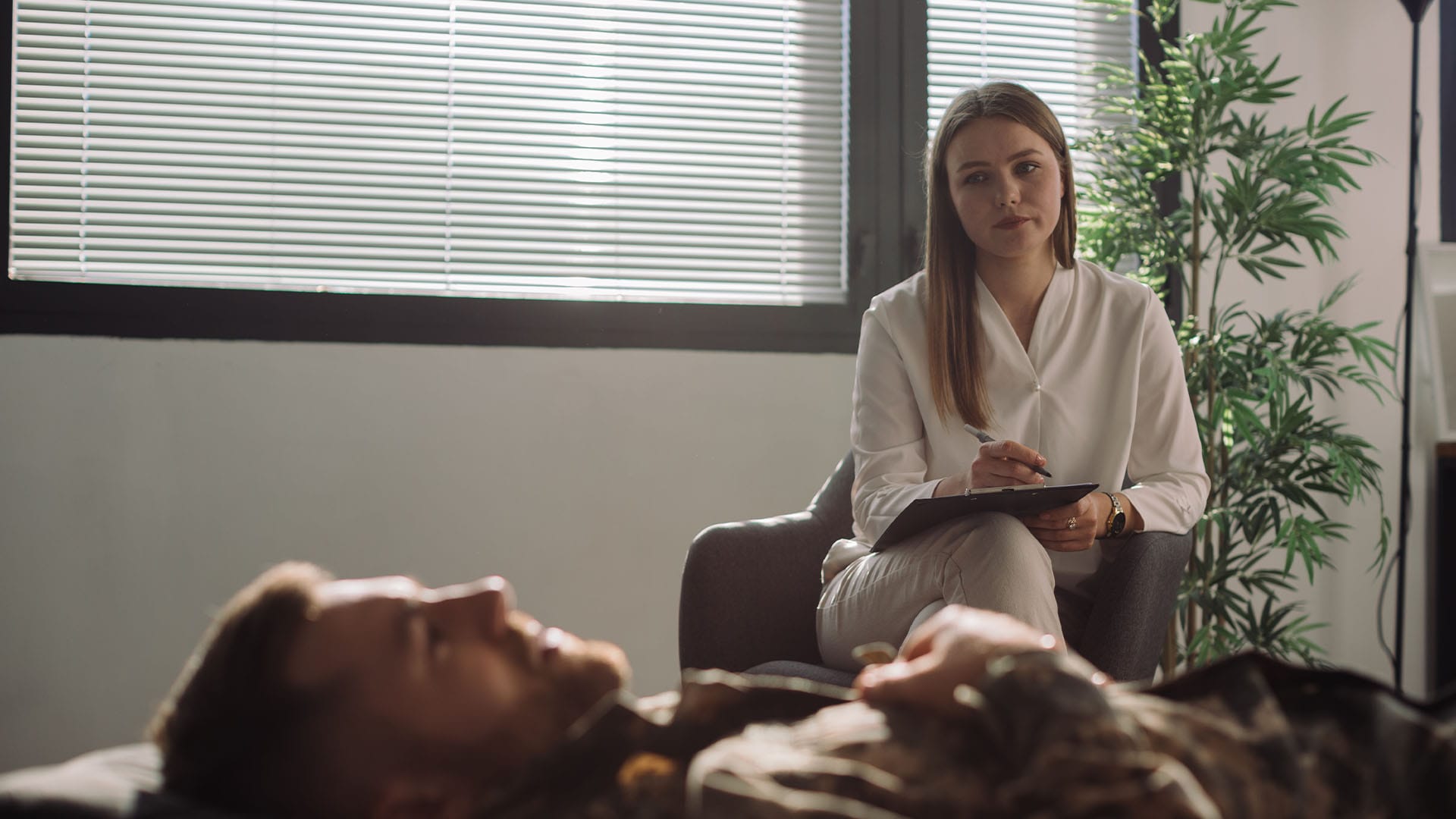 Therapist listening intently as client reclines during an extended therapy session
