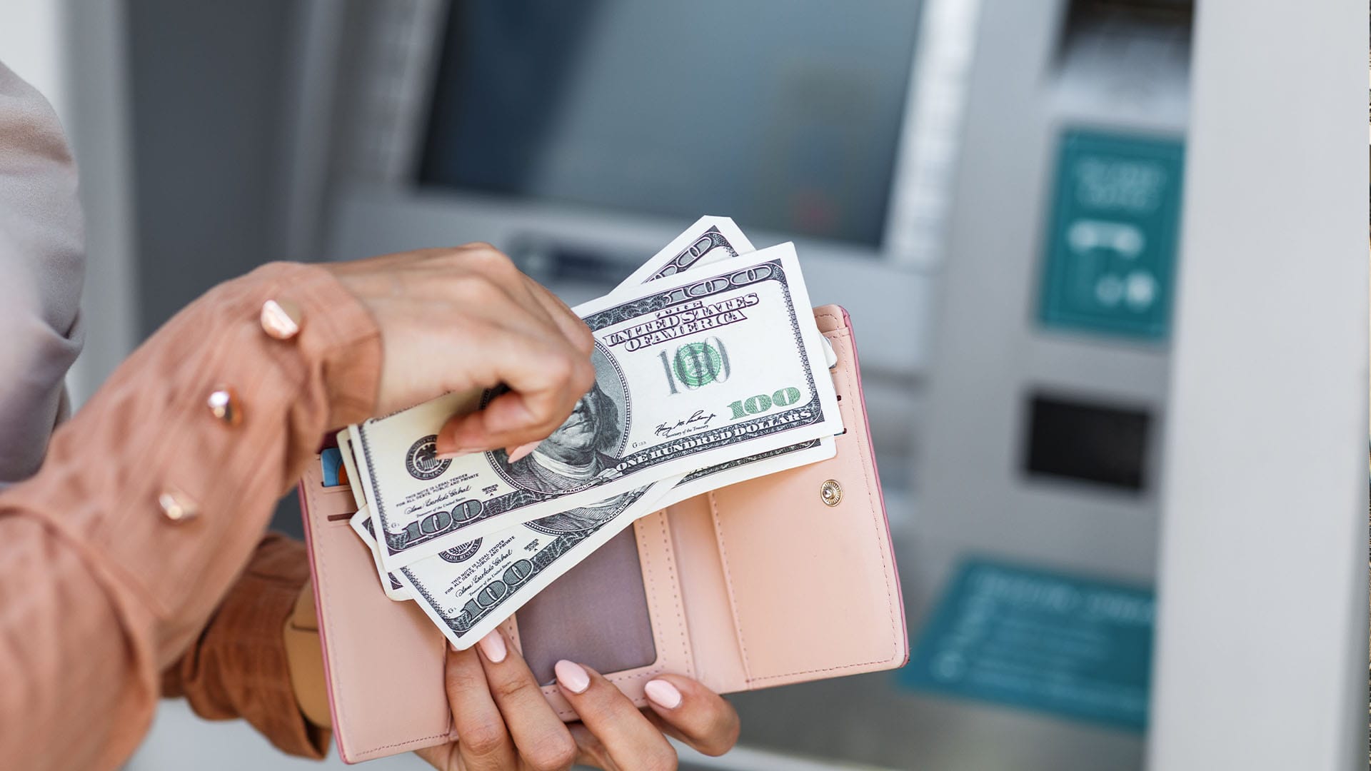Close-up of hands holding a wallet with hundred-dollar bills, symbolizing private pay options for discreet and personalized therapy in California.