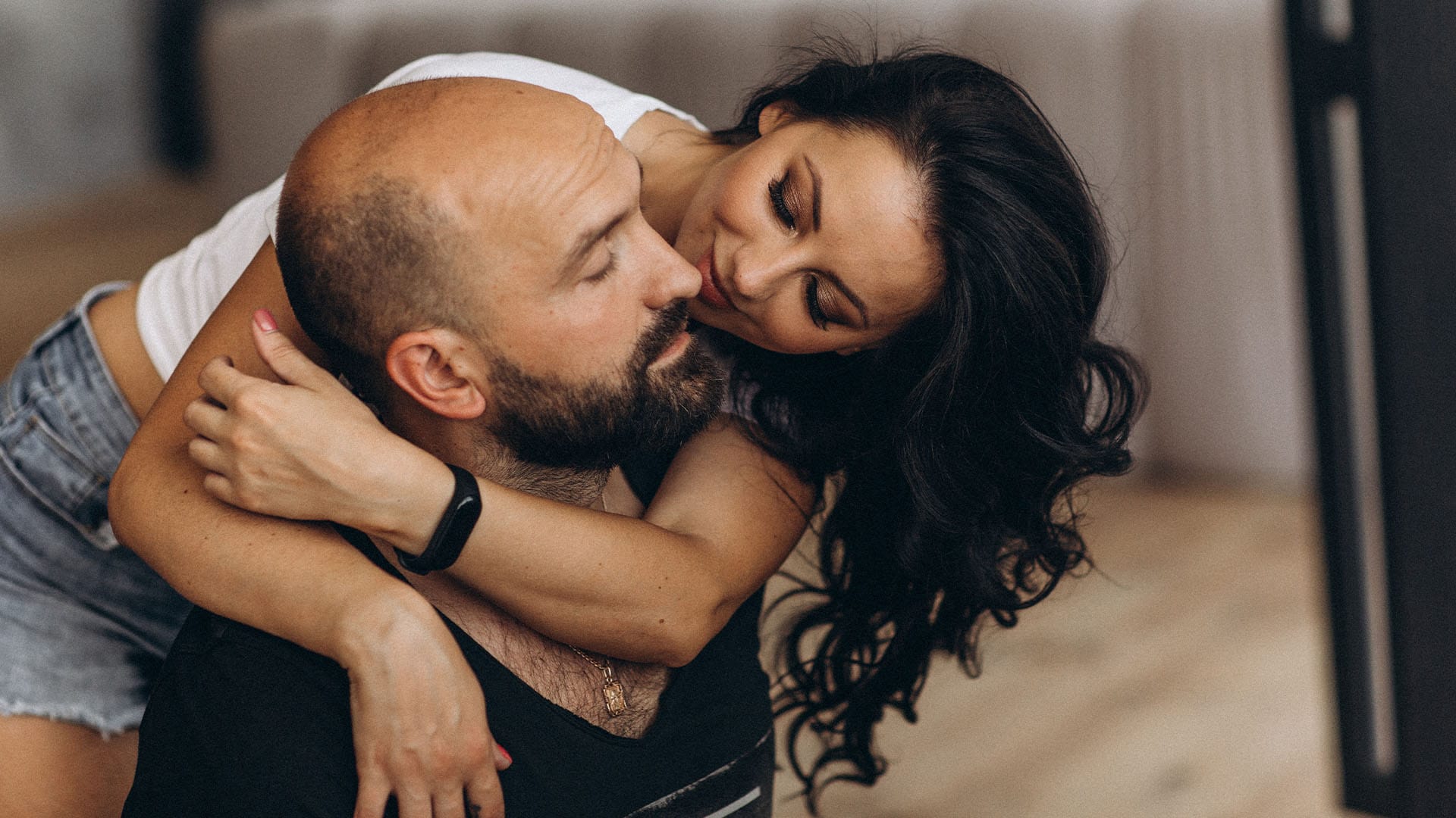 Loving couple embracing closely, gazing into each other’s eyes with warmth and affection
