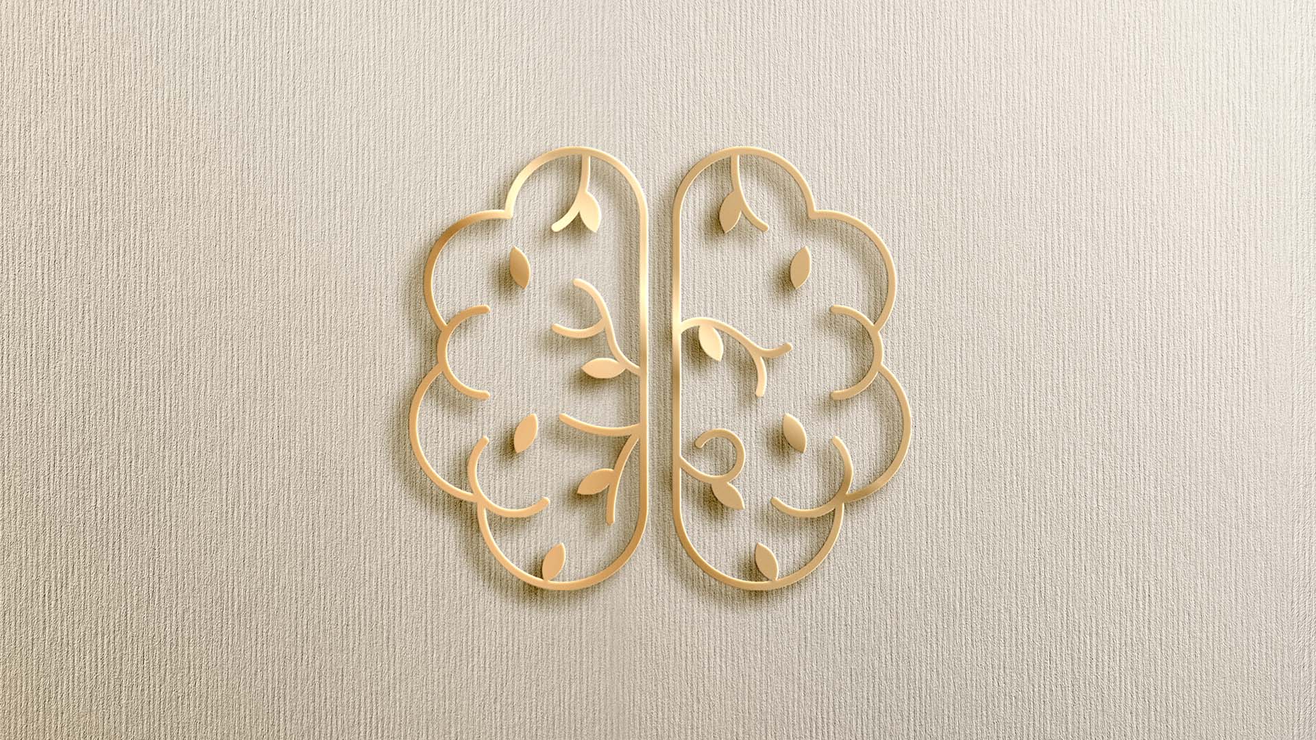 Gold brain-shaped logo with leaf details on a textured beige background, symbolizing growth, clarity, and modern therapy.