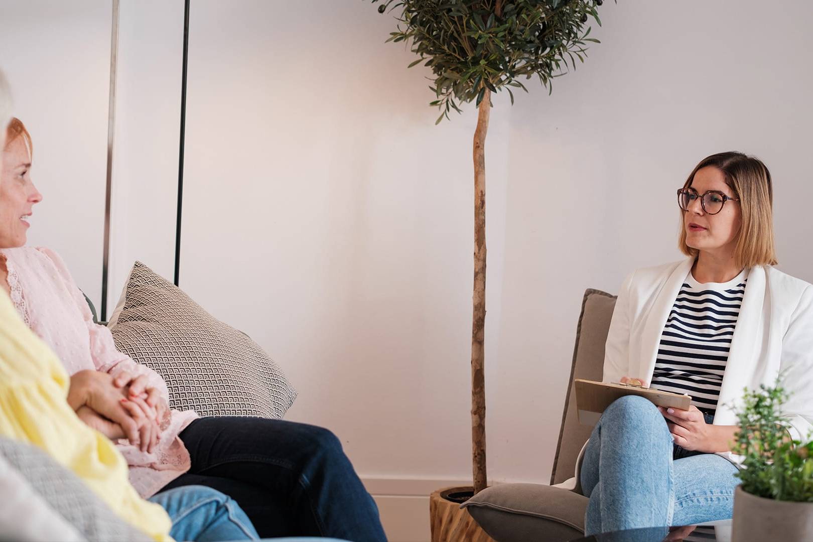 Therapist sitting with two women during a counseling session, representing premium therapy services in California for frequent travelers.