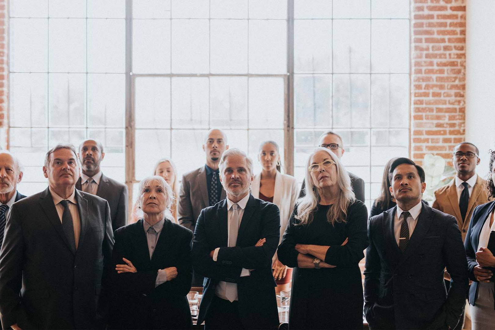 Therapy for attorneys in California — group of serious professionals in suits symbolizing high-stakes legal careers and workplace stress.