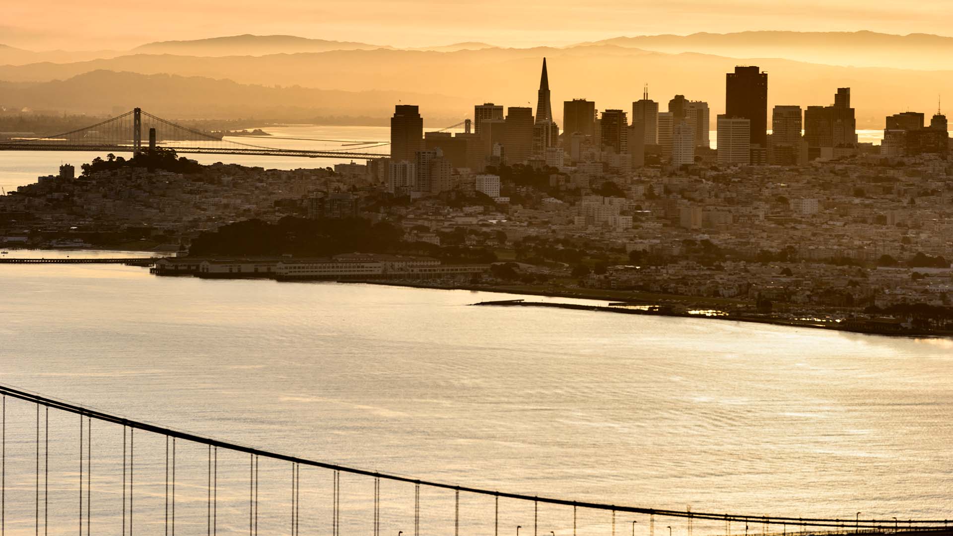 San Francisco skyline with Transamerica Pyramid and Bay Bridge at golden hour representing tech startup founder environment