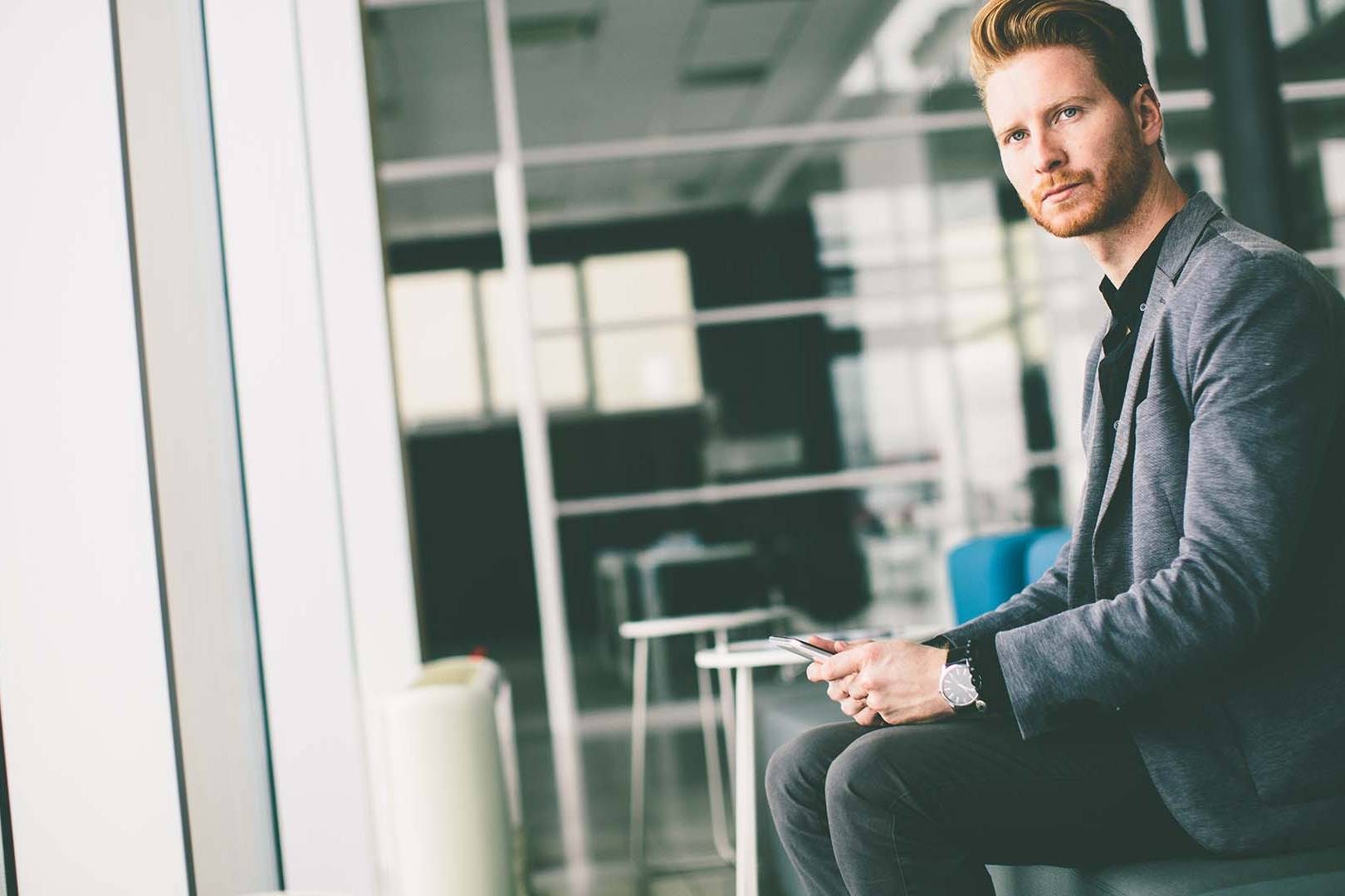 Senior executive in modern Bay Area tech office reflecting on leadership challenges, representing the need for specialized therapy for C-suite professionals