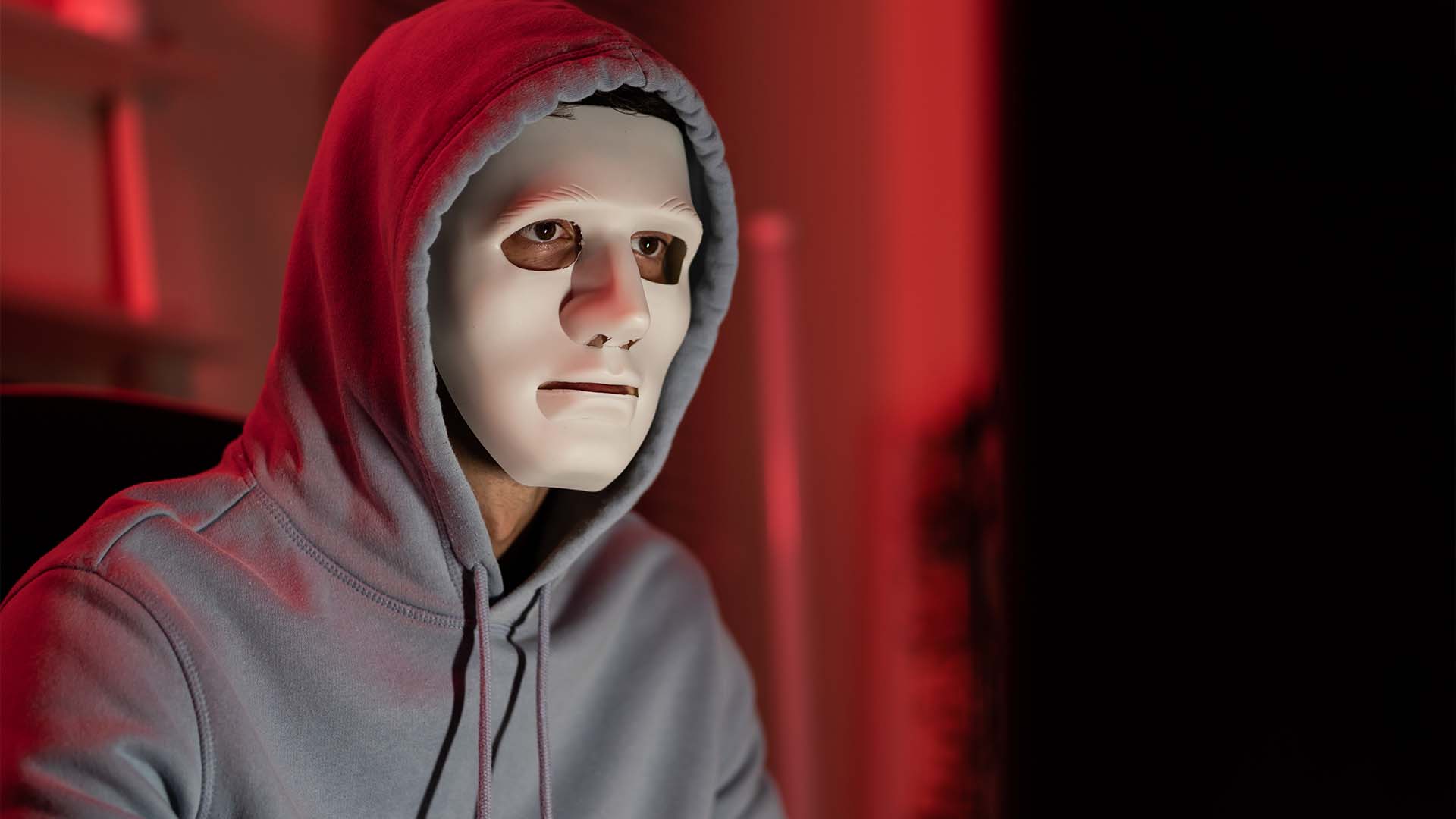 Person wearing white mask in hoodie symbolizing hidden identity and imposter syndrome feelings