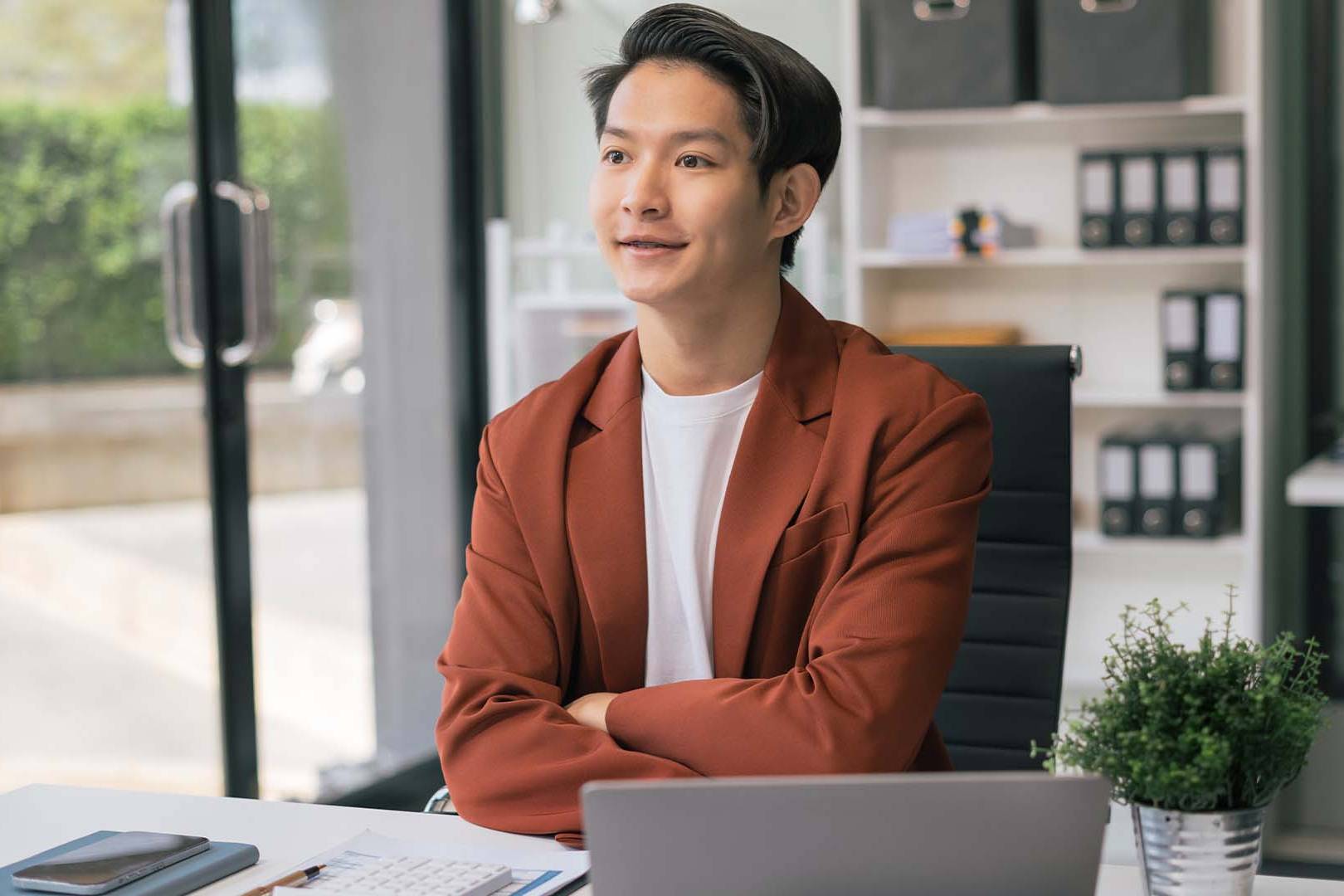Small business owner working at desk in modern Los Angeles office with natural lighting