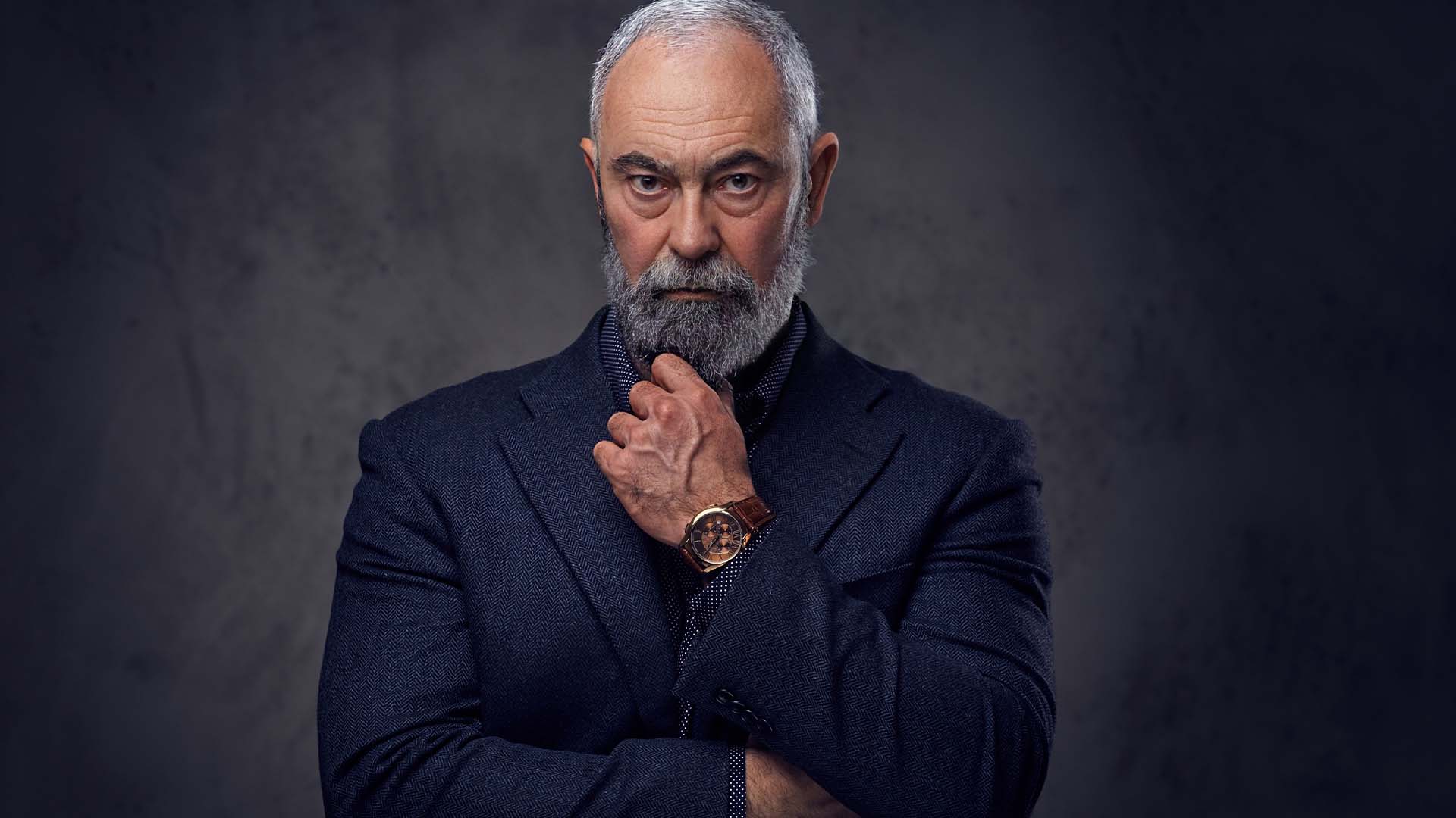 Distinguished senior professional in formal attire with contemplative intense expression, representing the burden of lifelong perfectionism in high achievers