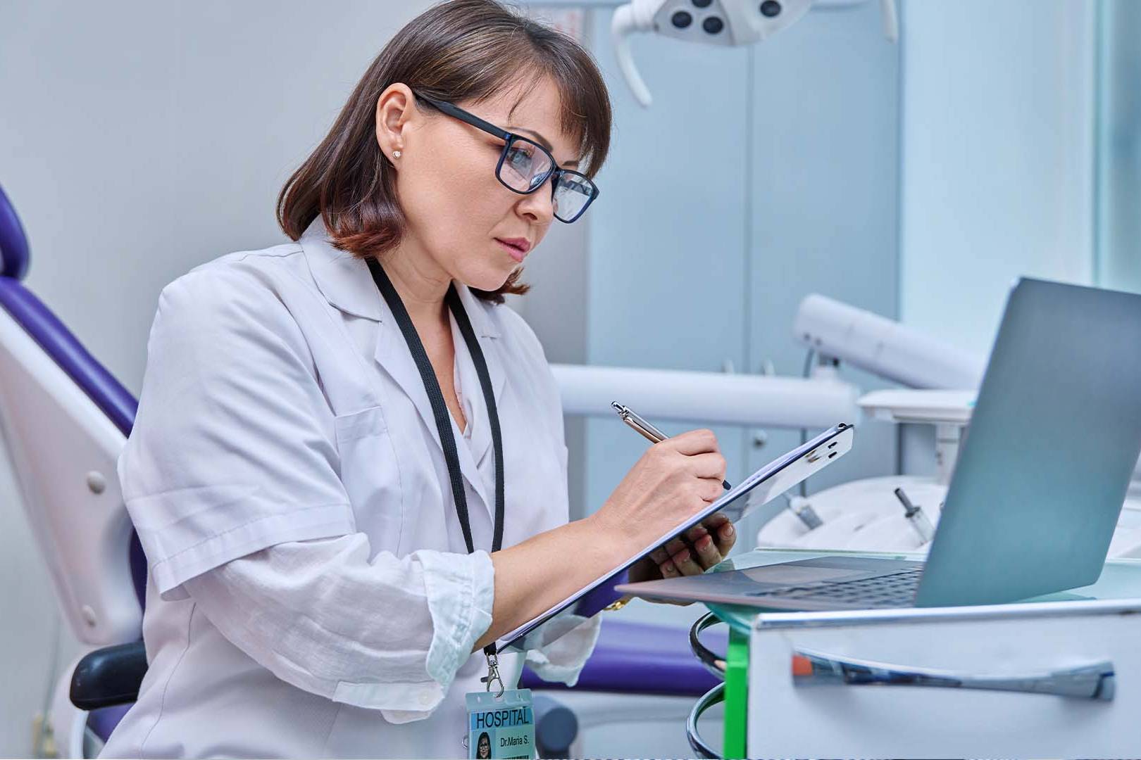 Female physician in white coat working at medical desk with stethoscope, representing doctors seeking completely confidential private-pay mental health support