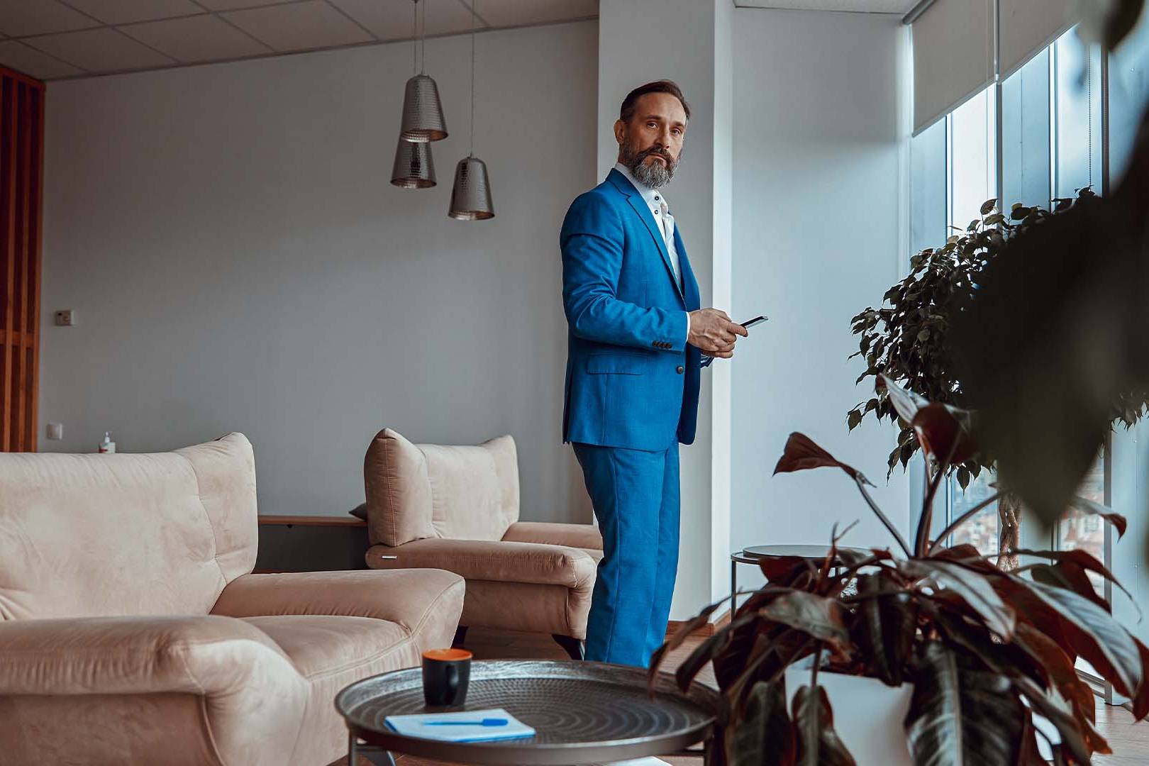 Entrepreneur in business attire standing contemplatively in empty office space, representing the emotional aftermath and processing of business failure