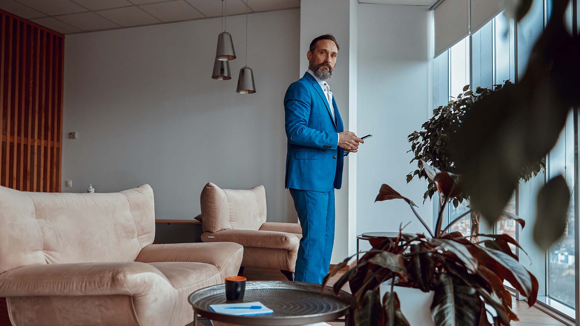 Entrepreneur in business attire standing contemplatively in empty office space, representing the emotional aftermath and processing of business failure