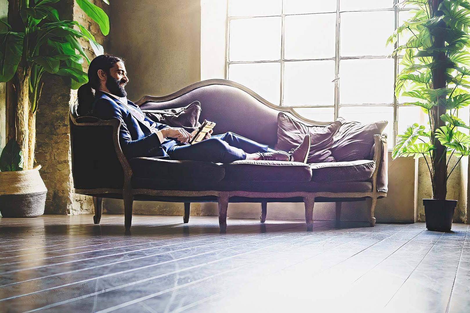 New law firm partner in business suit reclining thoughtfully in elegant office space, representing the complex transition and pressures of partnership