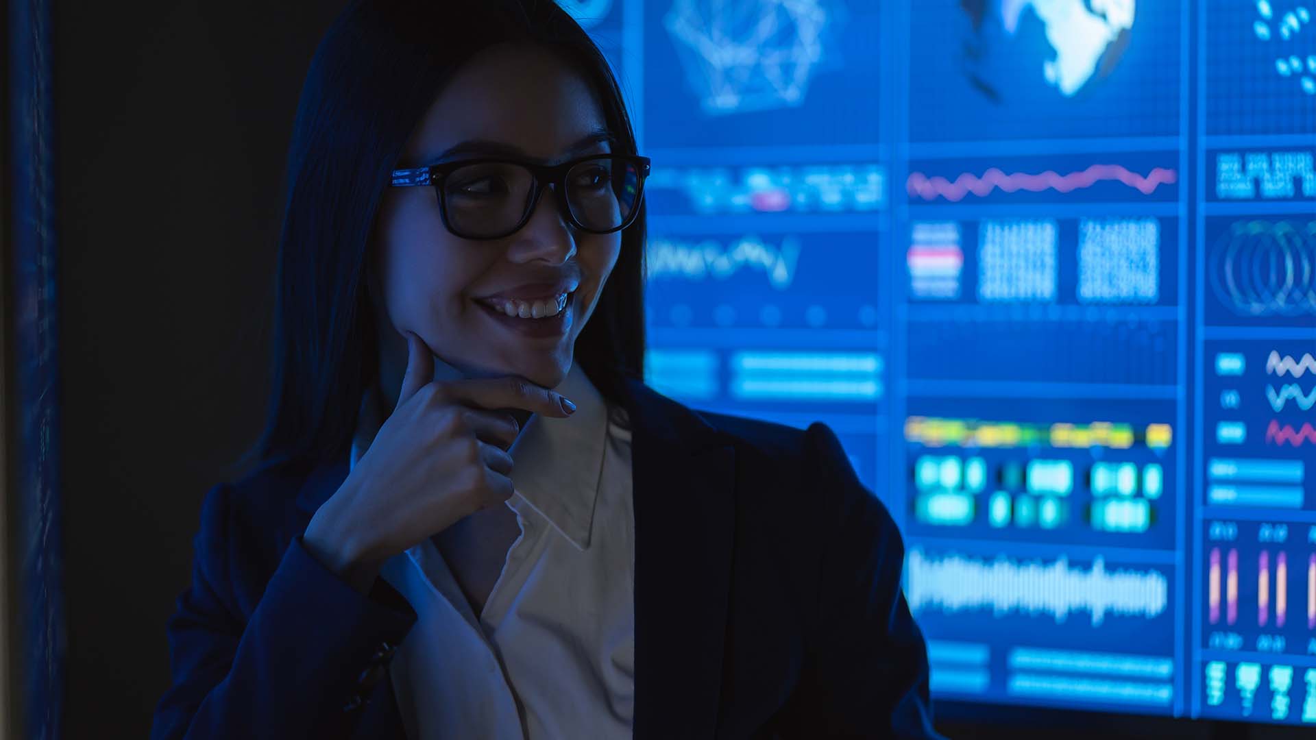 Female tech leader in professional attire with data screens, representing women navigating gender-specific career barriers and leadership challenges in technology industry