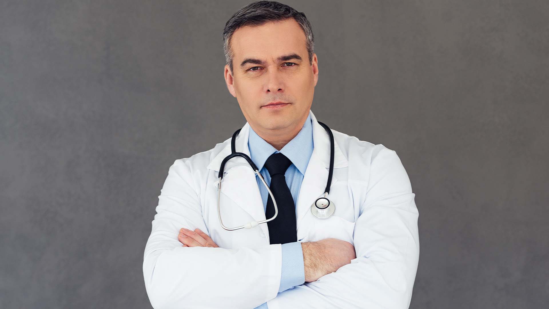 Serious male physician in a white coat with a stethoscope representing the 43 percent burnout rate among doctors.
