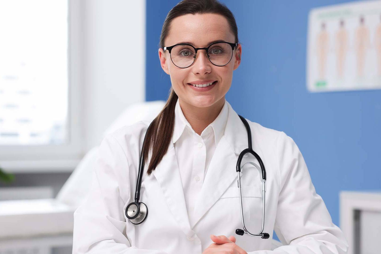 Professional female physician with glasses and a white coat representing research on moral injury in medicine.