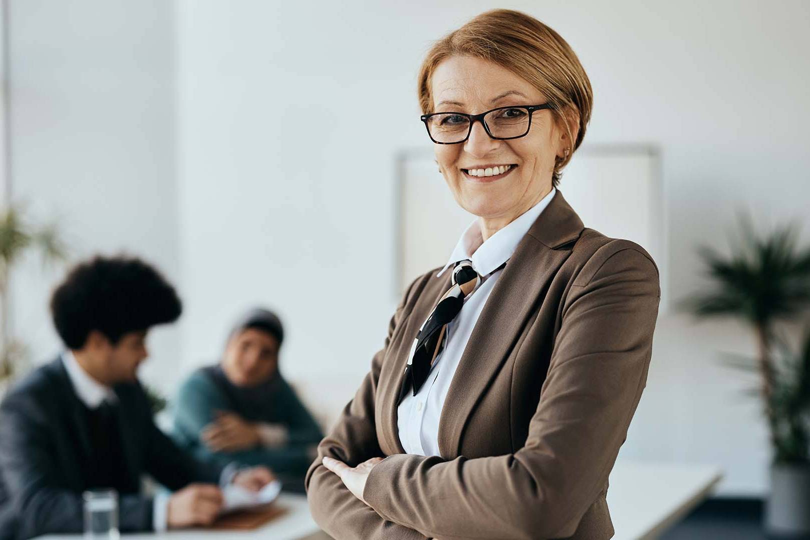 Confident businesswoman in office with colleagues
