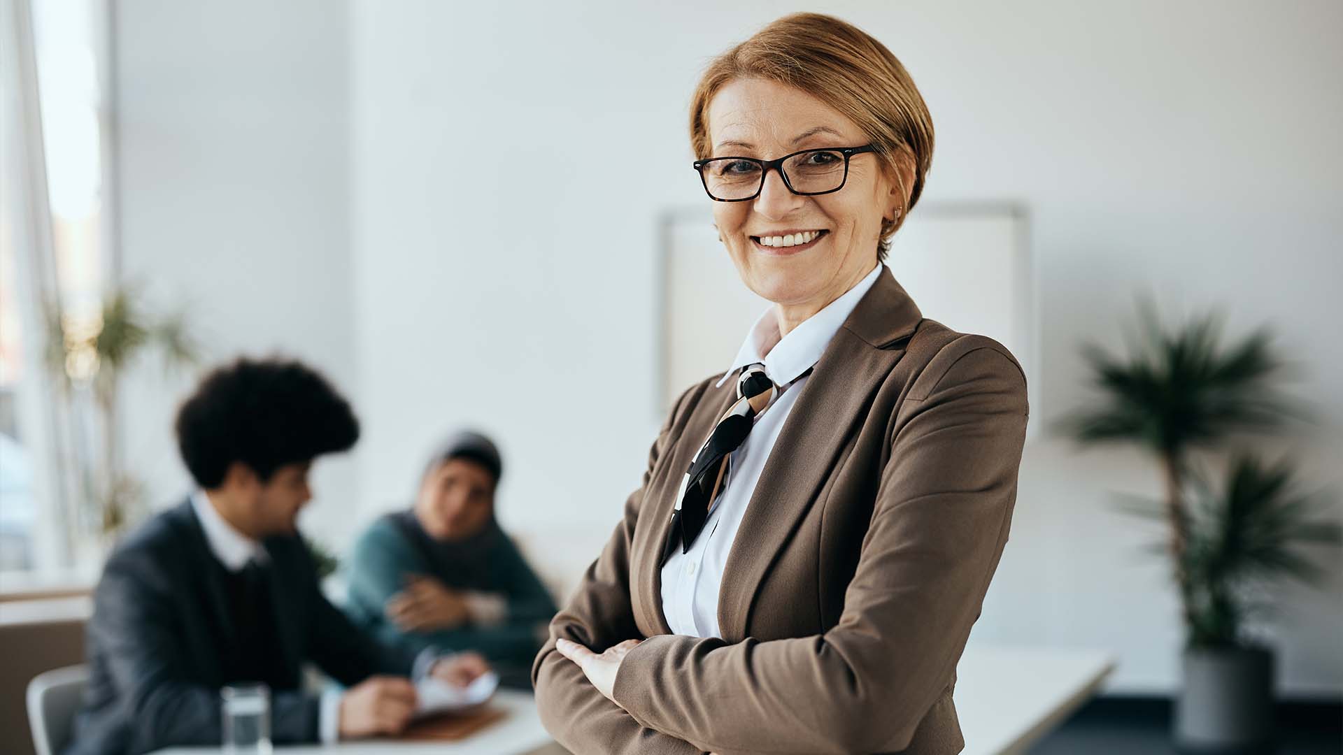Confident businesswoman in office with colleagues