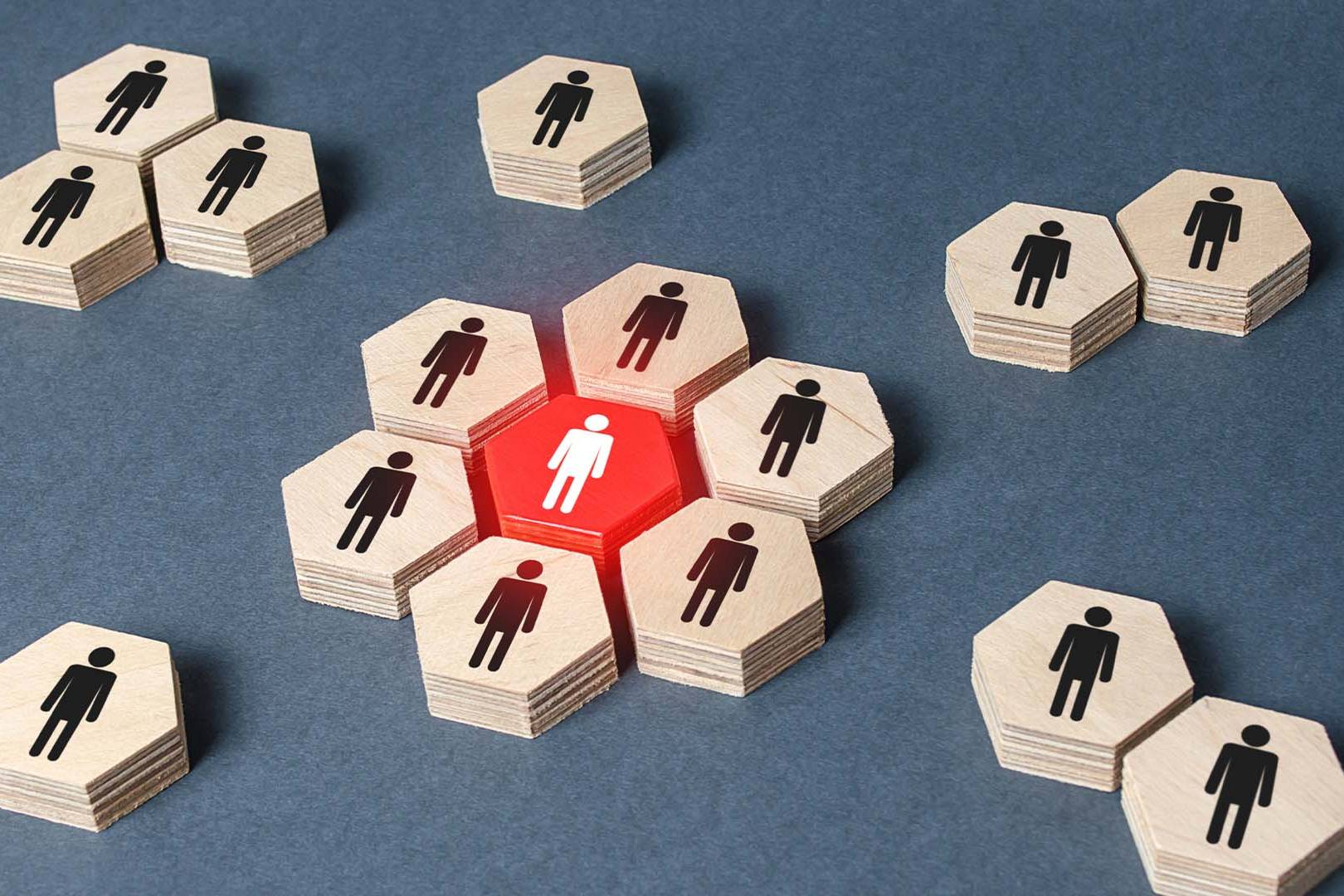 A bright red hexagonal tile with a white figure completely surrounded by wooden tiles with black figures.