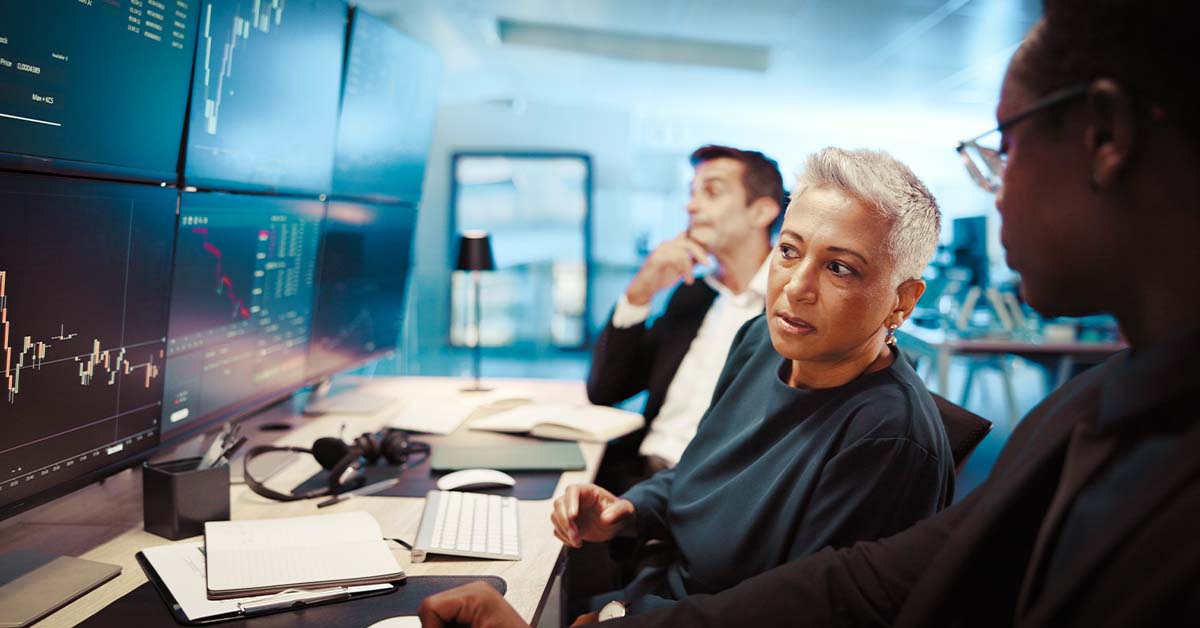 A focused team of financial professionals analyzing complex market data on a multi-monitor display, featured image for the article Therapy for Buy-Side Equity Research Analysts.