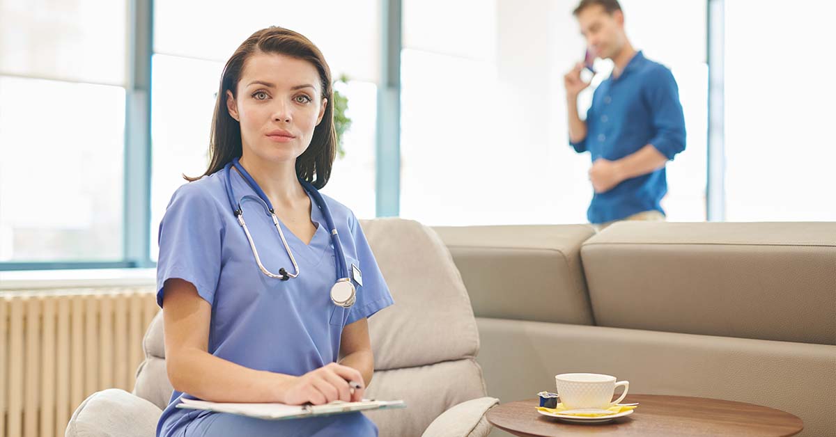 A female nurse in blue scrubs holding a clipboard while looking directly at the camera, featured image for the article Therapy for Chief Nursing Officers.