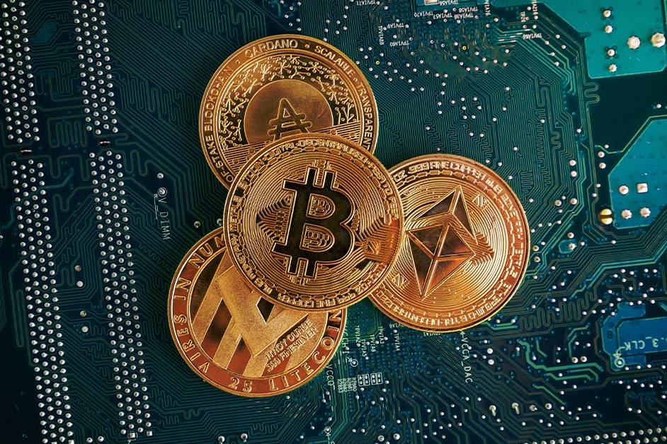Physical gold cryptocurrency coins including Bitcoin and Ethereum resting on a green computer circuit board, featured image for the article Therapy for Crypto and Blockchain Founders.