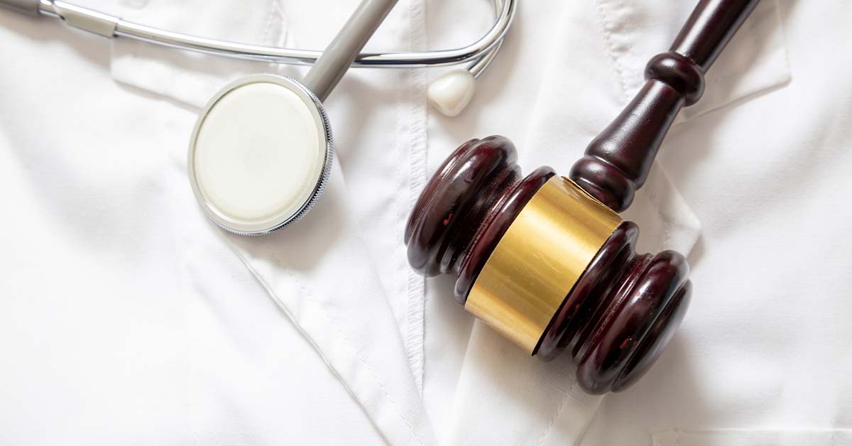 A wooden judge's gavel and a silver stethoscope resting together on a crisp white medical lab coat, featured image for the article Therapy for Healthcare Regulatory Attorneys.