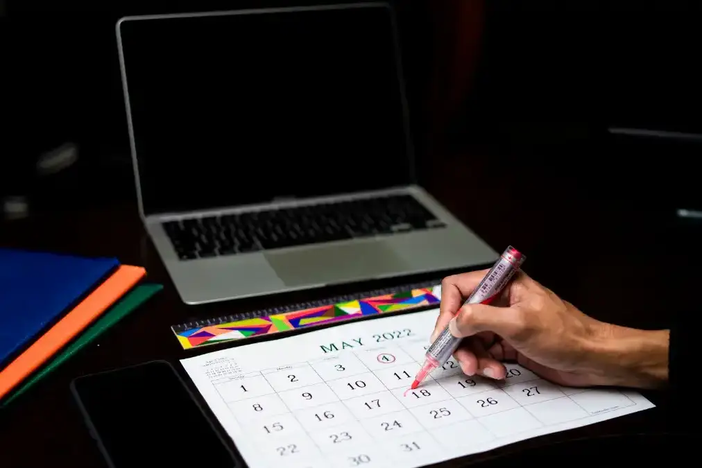 A person opening a calendar on a laptop with an open appointment this week, calm and relieved.
