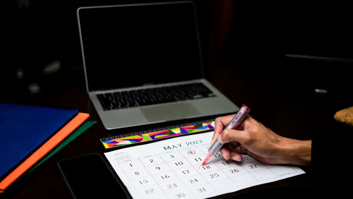 A person opening a calendar on a laptop with an open appointment this week, calm and relieved.