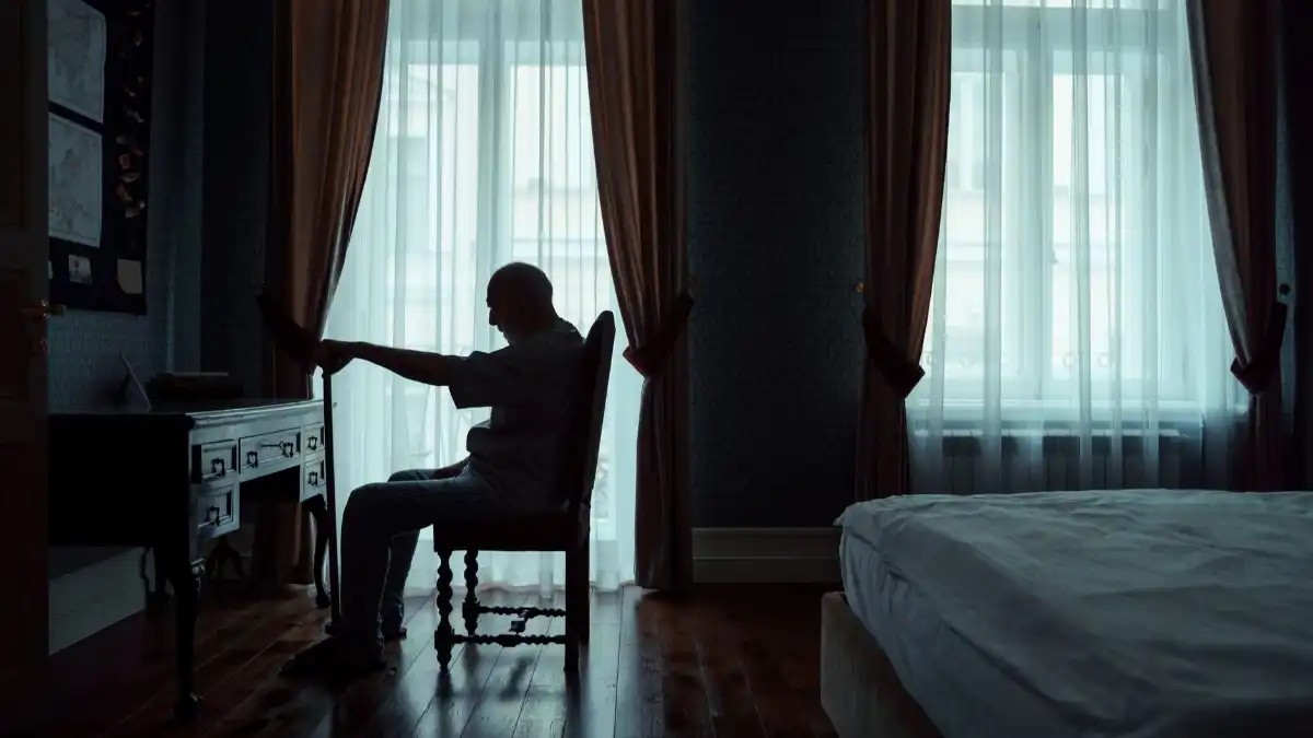 A former executive sitting alone in a quiet study at home, reflecting after a career change.