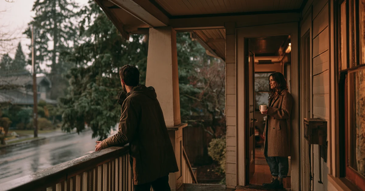 Couple a few feet apart on the porch of a Seattle craftsman house on a gray evening, illustrating couples therapy Seattle with CEREVITY