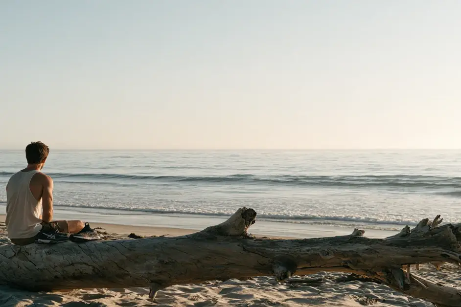 Man sitting quietly on a San Diego beach at dawn looking at the ocean, illustrating EMDR therapy San Diego with CEREVITY